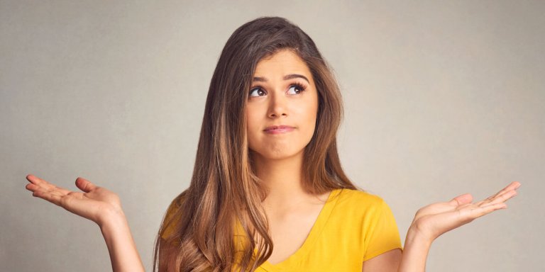 Picture of a young woman holding her hands out looking undecided
